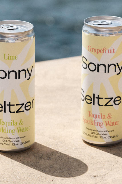 Two cans of Sonny Seltzer in the sun